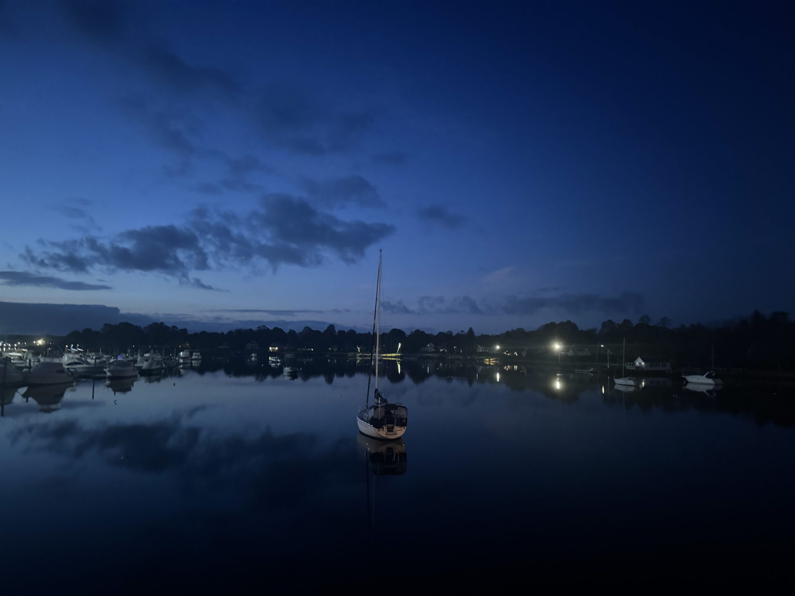 harbor with single sailboat just before sunrise